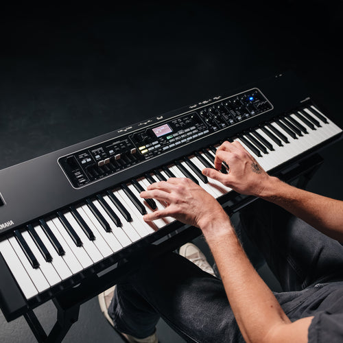 Overhead view of a musician playing the Yamaha CK76 stage keyboard on a stand