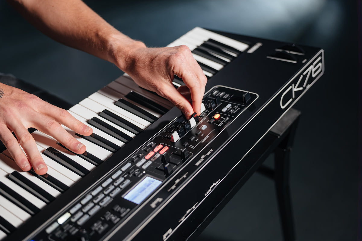 Close-up of a musician adjusting the organ drawbars on the Yamaha CK76 stage keyboard