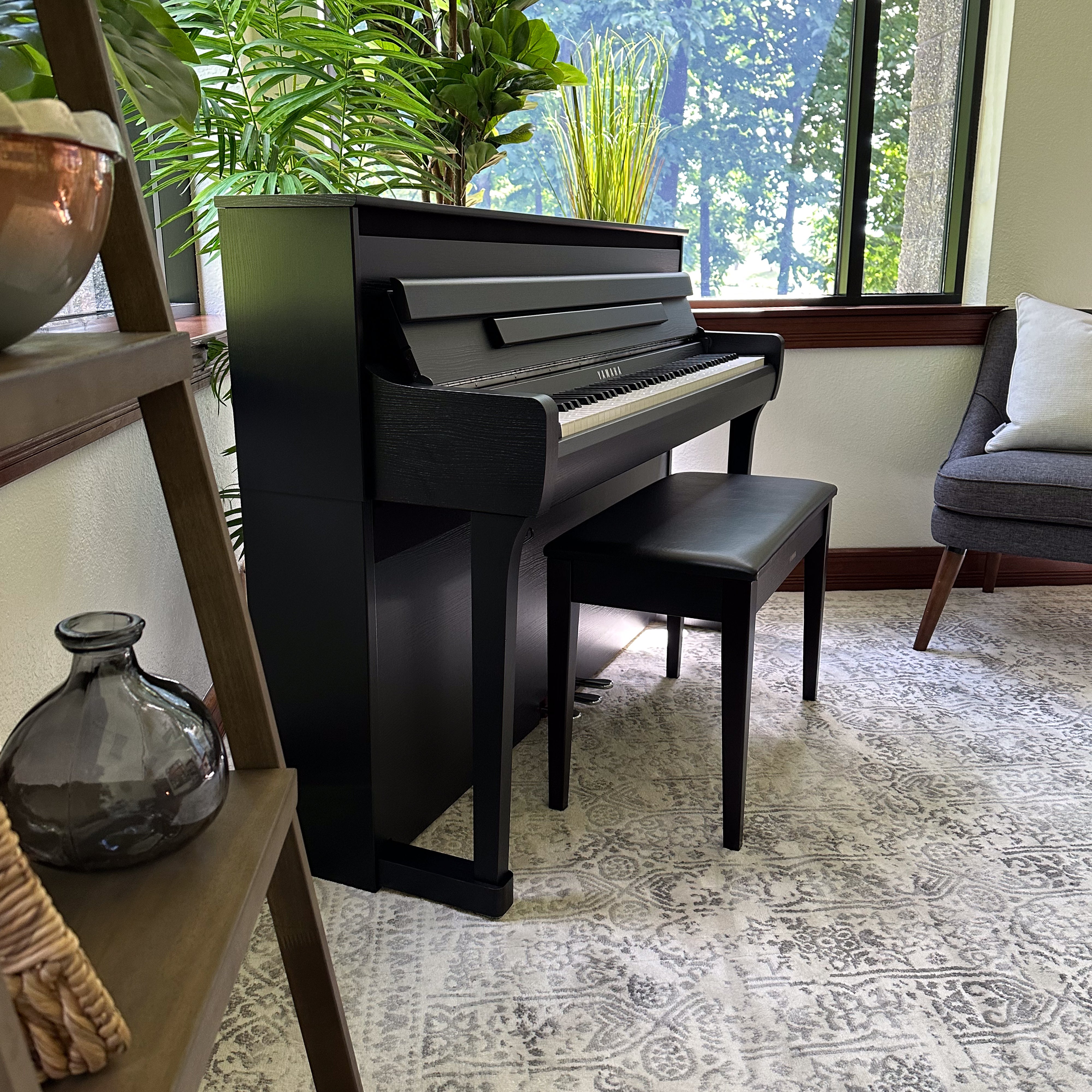 Yamaha Clavinova CLP-885 Digital Piano - Matte Black in a stylish room, side view