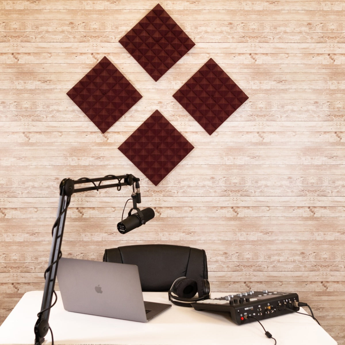 Lifestyle image of the acoustic foam panels mounted on a studio wall with a podcasting setup in front.