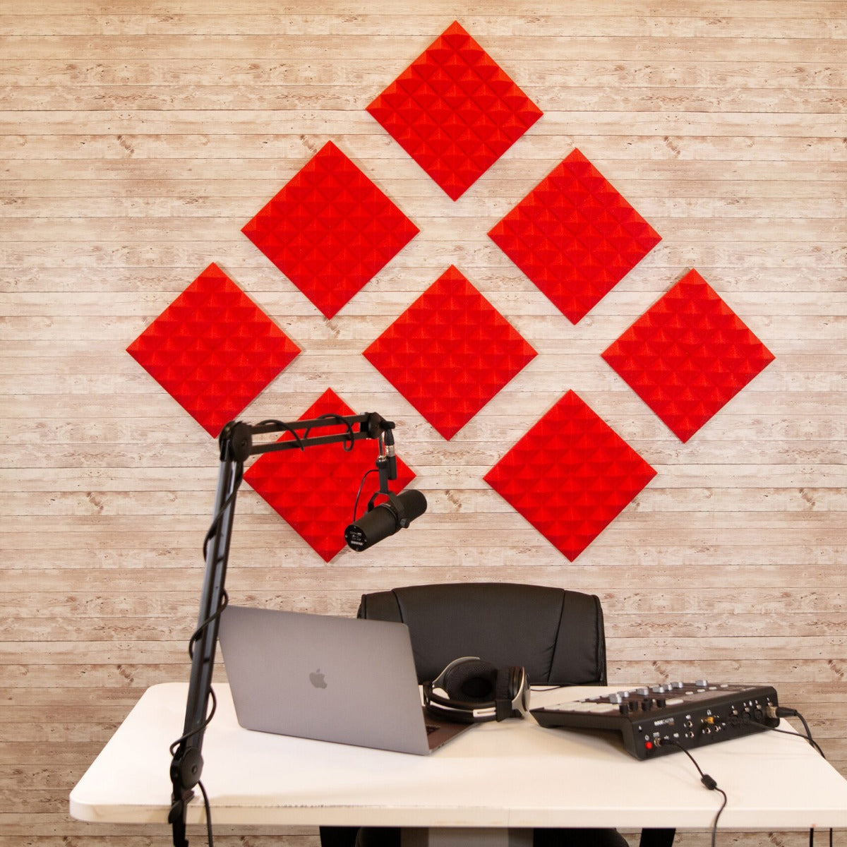 Lifestyle image of the acoustic foam panels mounted on a studio wall with a podcasting setup in front