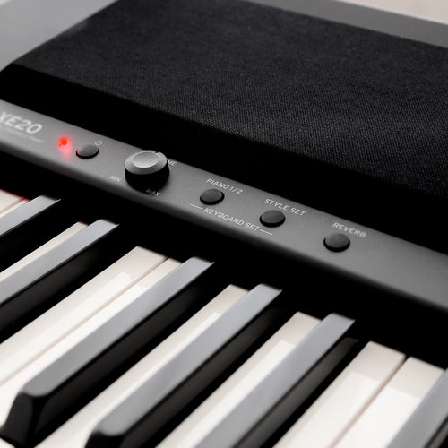 Closeup detail view of Korg XE20 Home Digital Ensemble Piano top panel showing left speaker grille