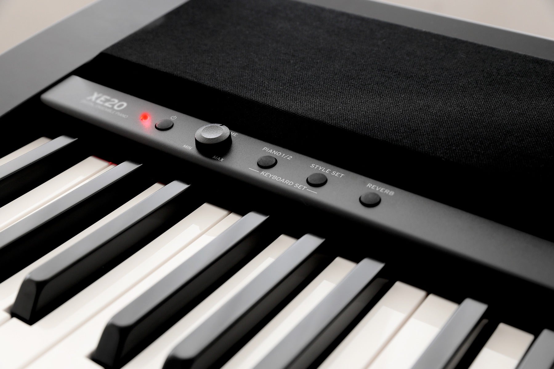 Closeup detail view of Korg XE20 Home Digital Ensemble Piano top panel showing left speaker grille