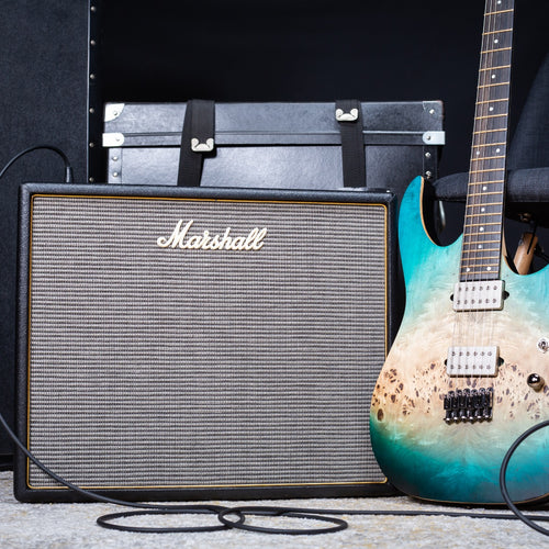 Image of the Marshall Origin20C 20W Tube Combo Amp with a guitar to the right